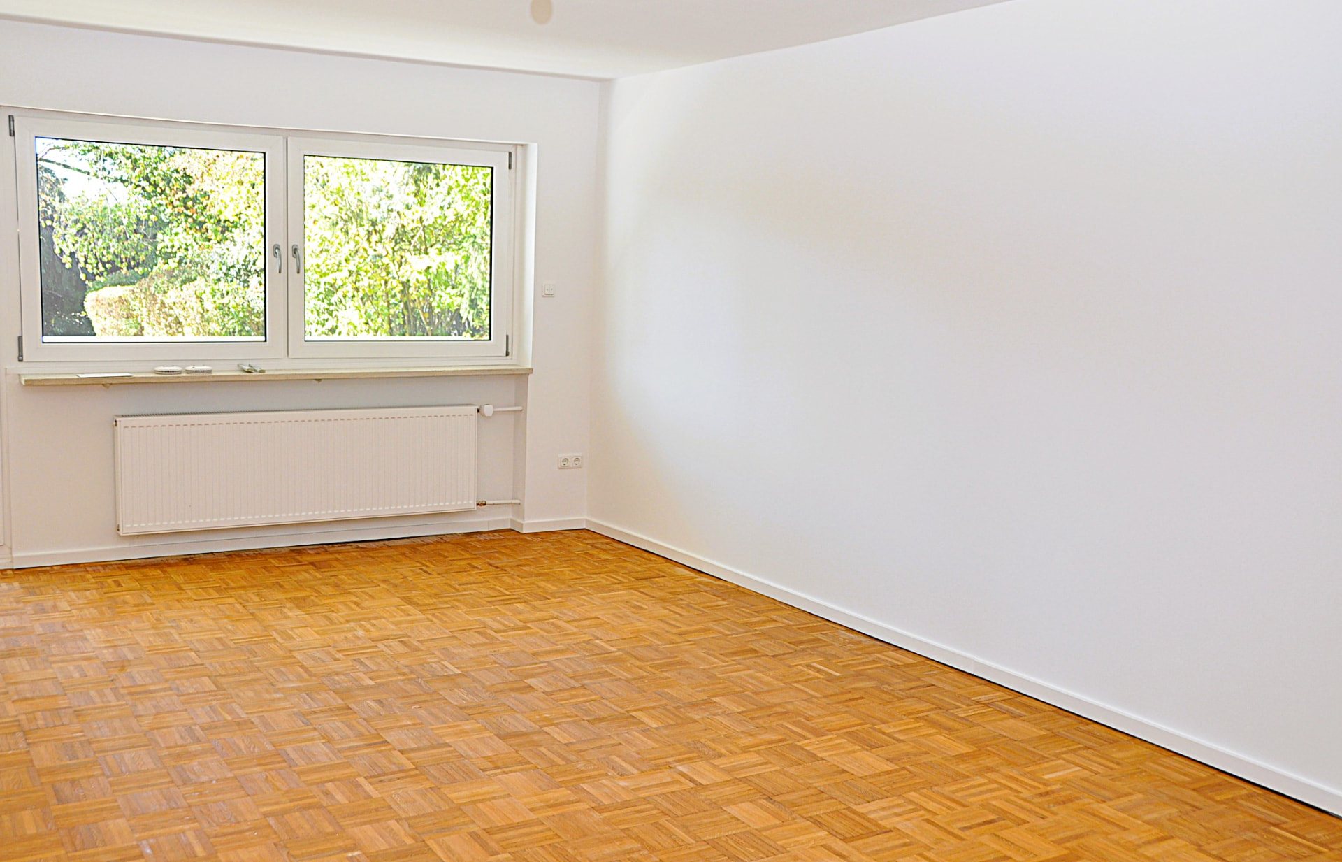 Bright living room with parquet and large window