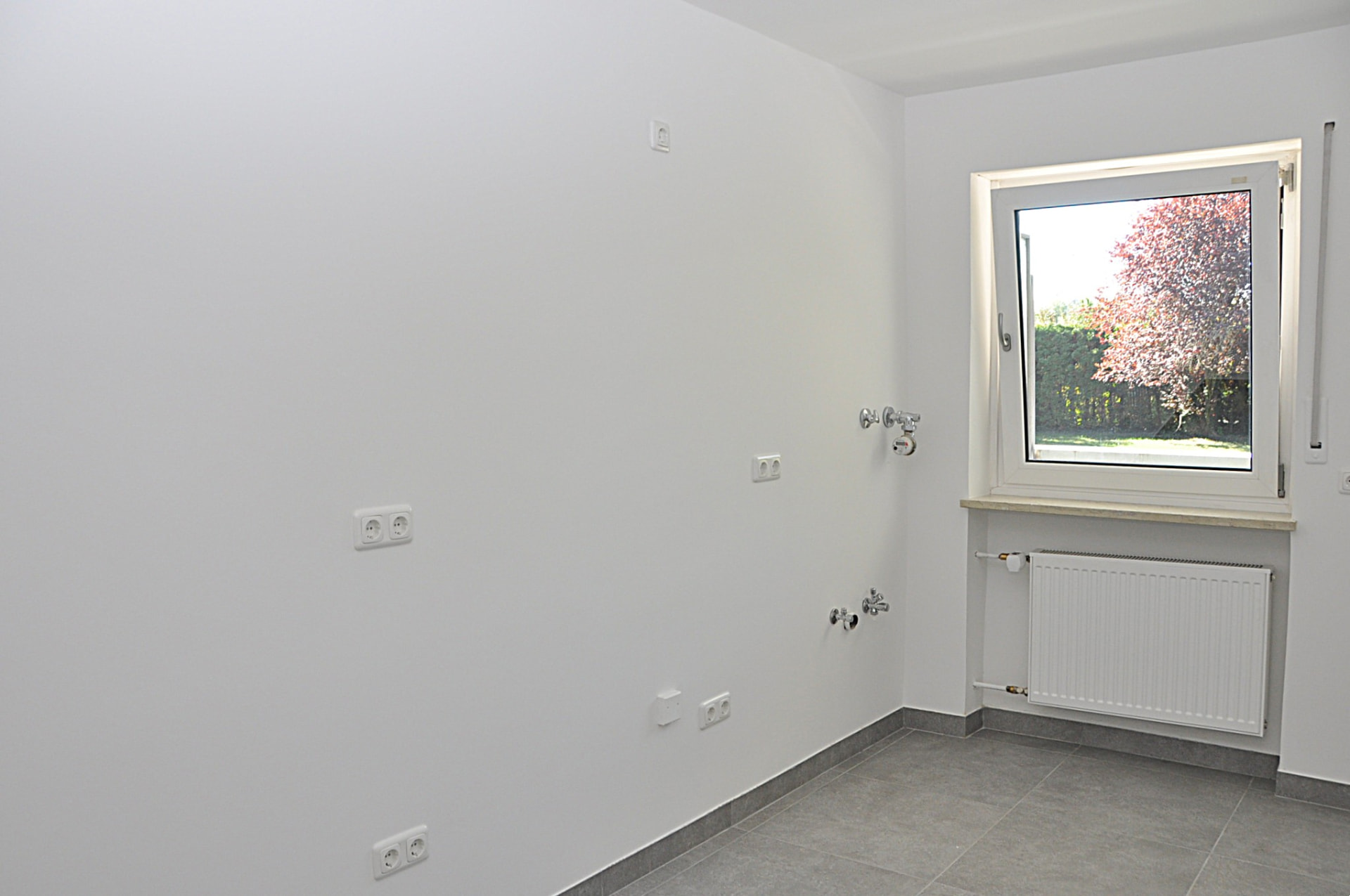 Kitchen with new floor tiles and garden-facing window