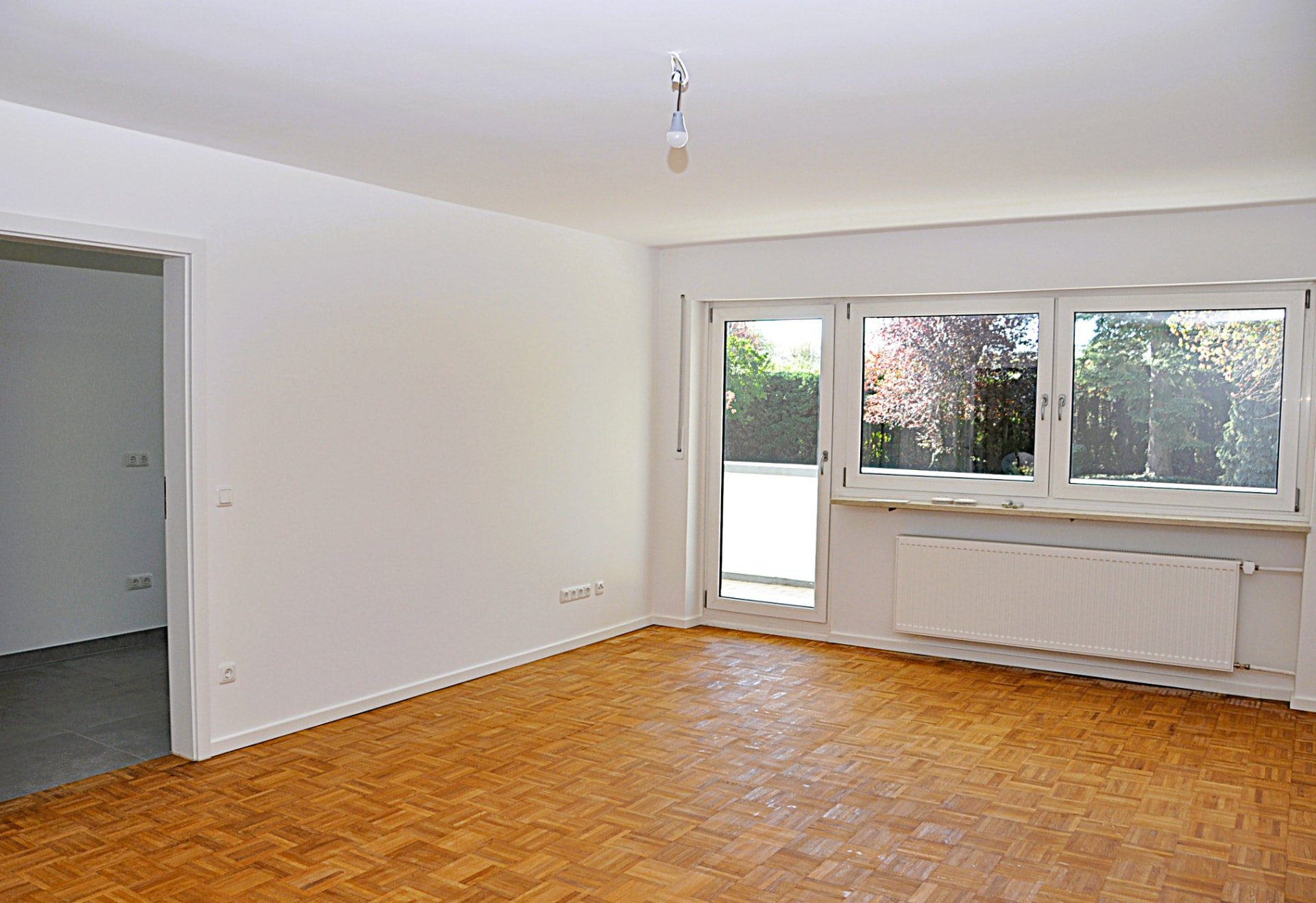 Living room with window front and balcony door