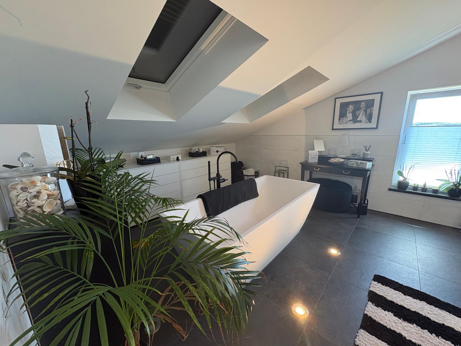 Bathroom on the gallery level with freestanding bathtub under skylights
