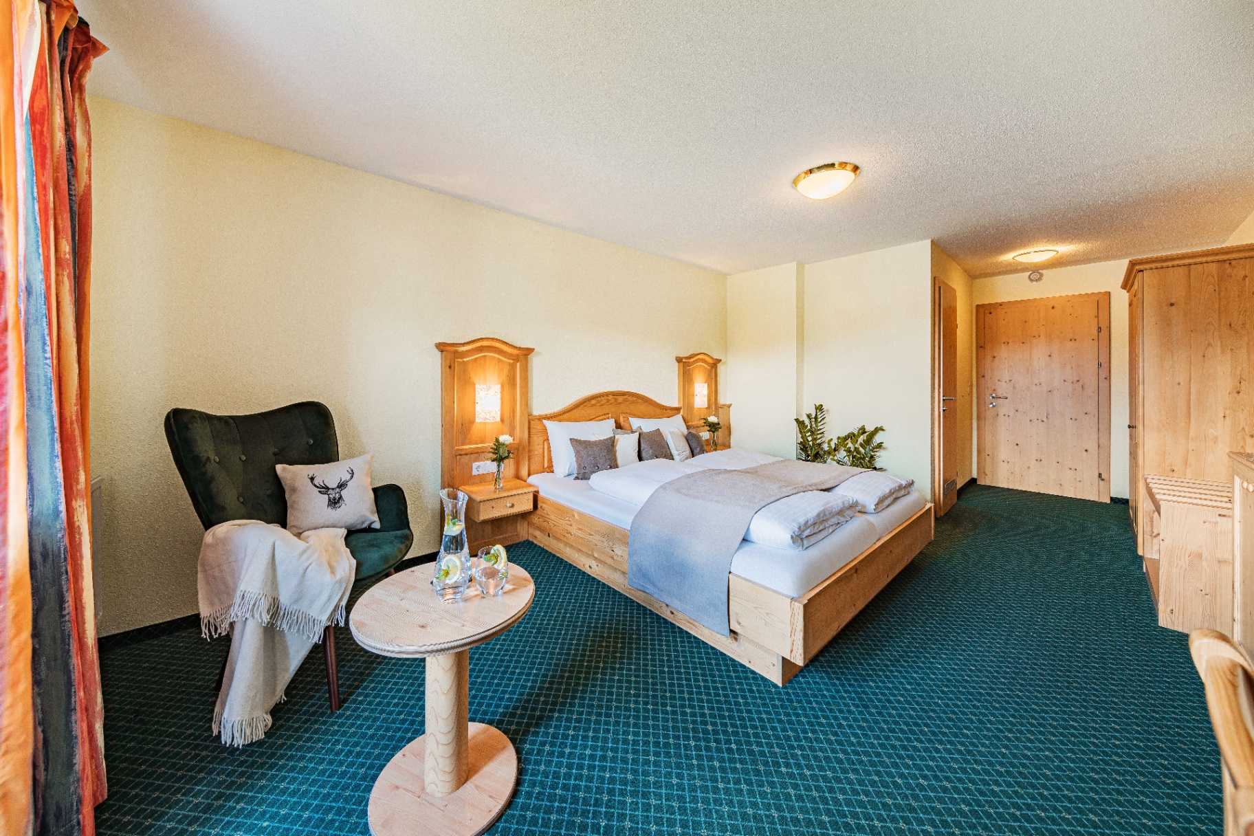 Classic hotel room with Swiss pine furniture and wing chair